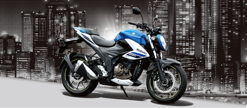 Load image into Gallery viewer, A blue and white 2025 Suzuki GSX 250 LAMS motorcycle positioned in front of a stylized black-and-white city skyline at night.