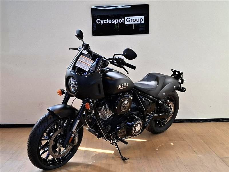 Load image into Gallery viewer, A black Indian Sport Chief motorcycle is parked indoors on a wooden floor against a light gray wall, with a 'Cyclespot Group' sign visible above it.
