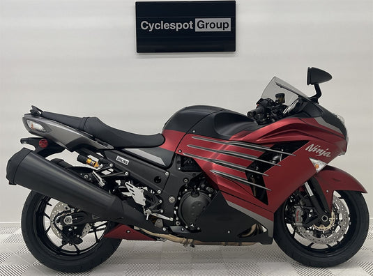Red and black 2025 Kawasaki Ninja ZX 14 R SE motorcycle on display with 'Cyclespot Group' sign in the background
