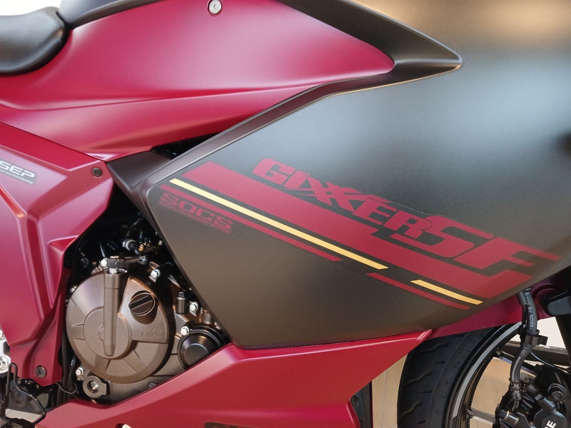 Load image into Gallery viewer, Close-up of a red and black 2025 Suzuki GSX 250 FR motorcycle with 'Gixxer' branding.
