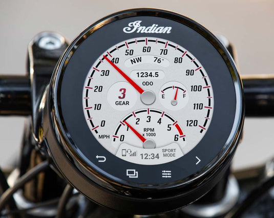 Close-up of an Indian motorcycle dashboard instrument cluster with a black bezel, white face, red needles, and digital readouts including ODO and SPORT MODE.