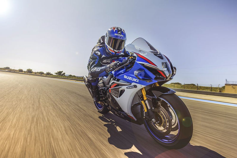 Load image into Gallery viewer, Motorcycle racer on a 2027 Suzuki GSX-R 1000 R on a track with clear blue sky
